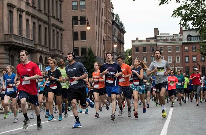 Runners sprinting down a Boston street