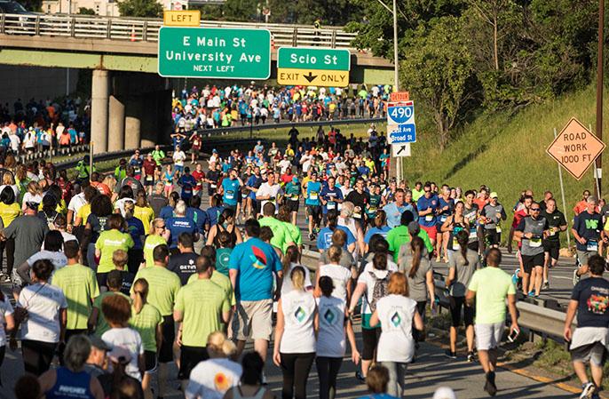 A very large crowd of runners makes their way down a closed-off highway in Rochester for the 2017 JPM Corporate Challenge Rochester